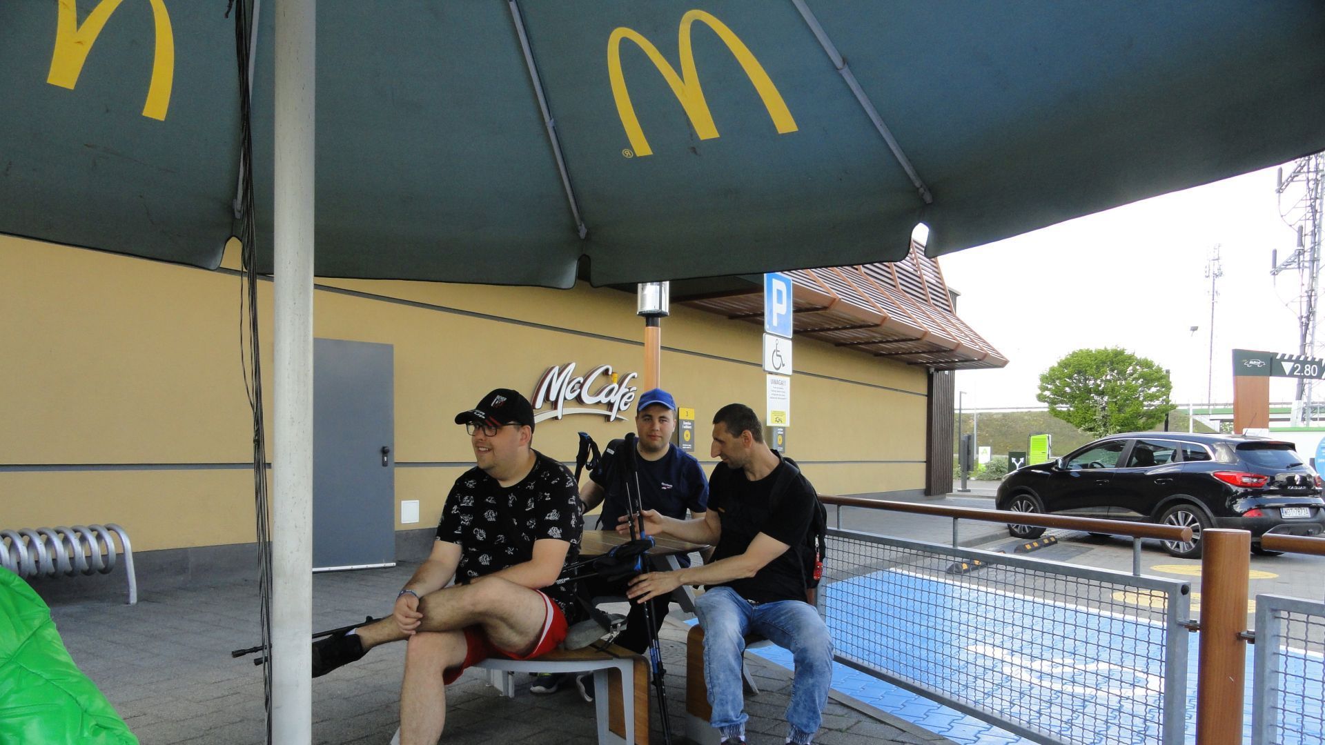 Uczestnicy podczas spaceru z kijkami do nordic walking zatrzymali się przy restauracji McDonald's.