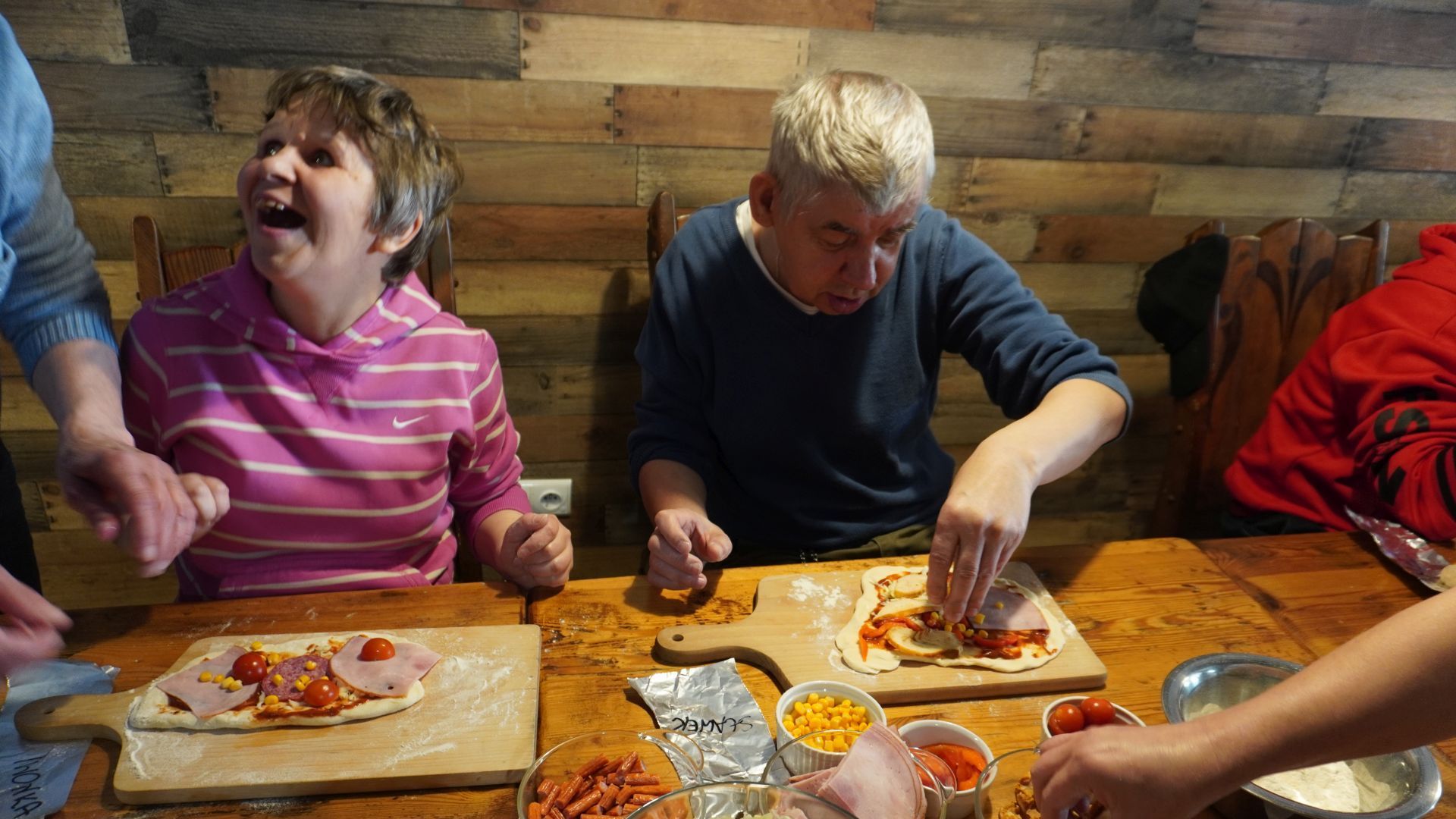 Uczestnicy przygotowują swoje pizze podczas Warsztatów Wypieku Pizzy.