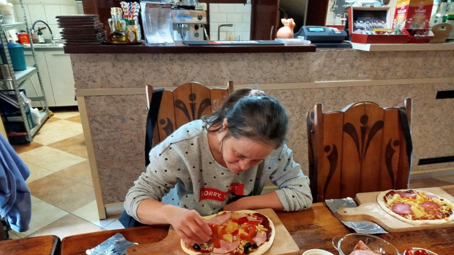 Uczestniczka Agnieszka P. przygotowuje pizzę podczas ''Warsztatów Wypieku Pizzy''.