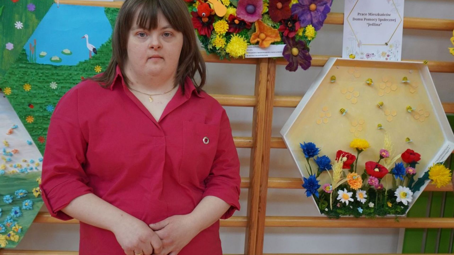 Uczestniczka Sylwia W.. na tle swojej pracy konkursowej ''Miododajna łąka w plastrze miodu''.