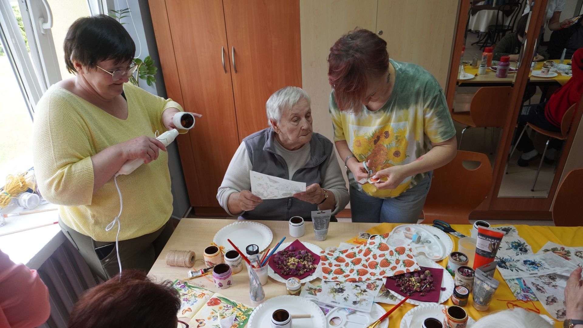 Ozdabianie słoiczków na świece podczas warsztatów ''W świecie wosku i zapachów''.