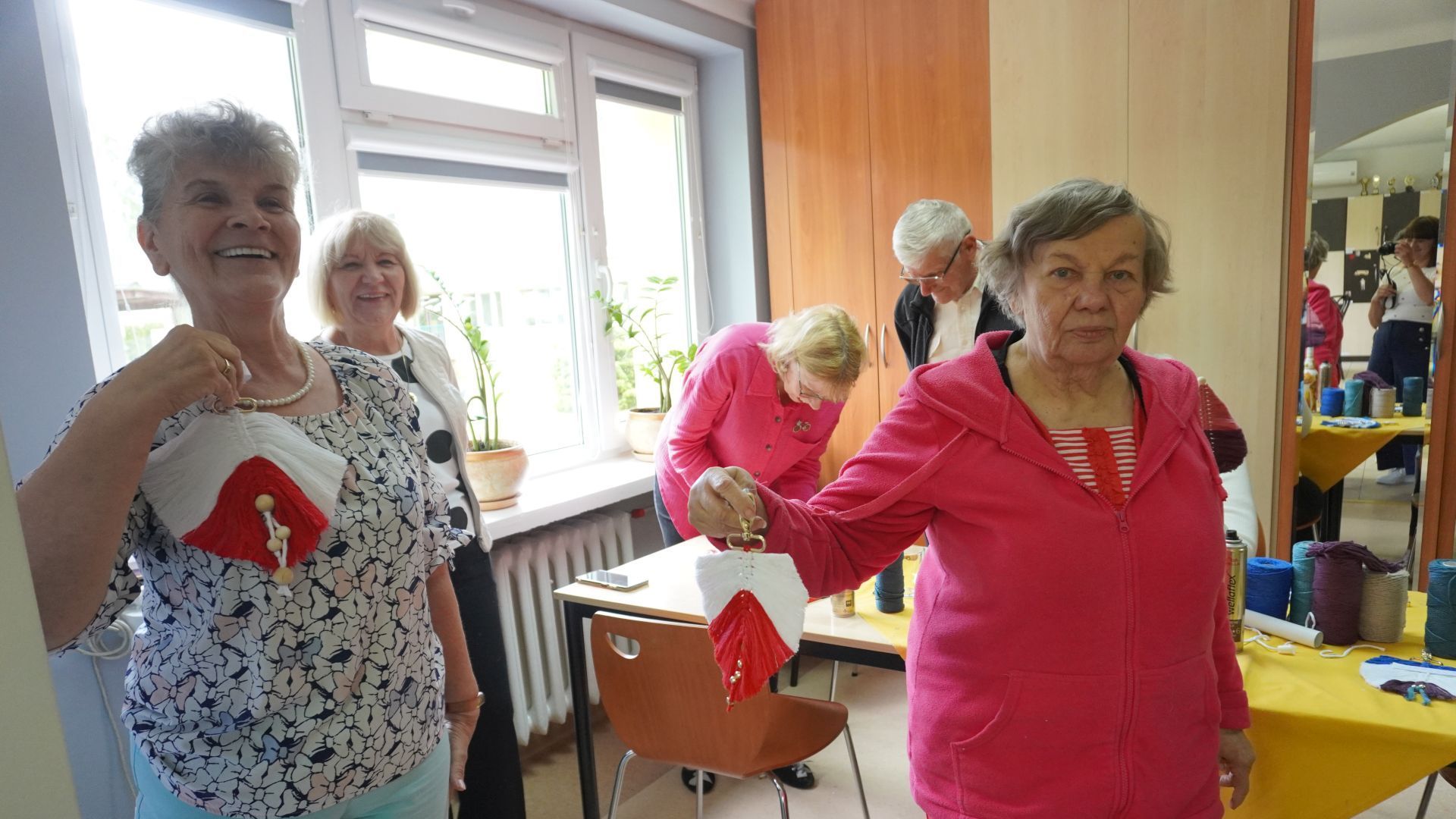 Uczestniczki warsztatów ''Po sznureczku do breloczka'' pokazują breloczki, które wykonały.