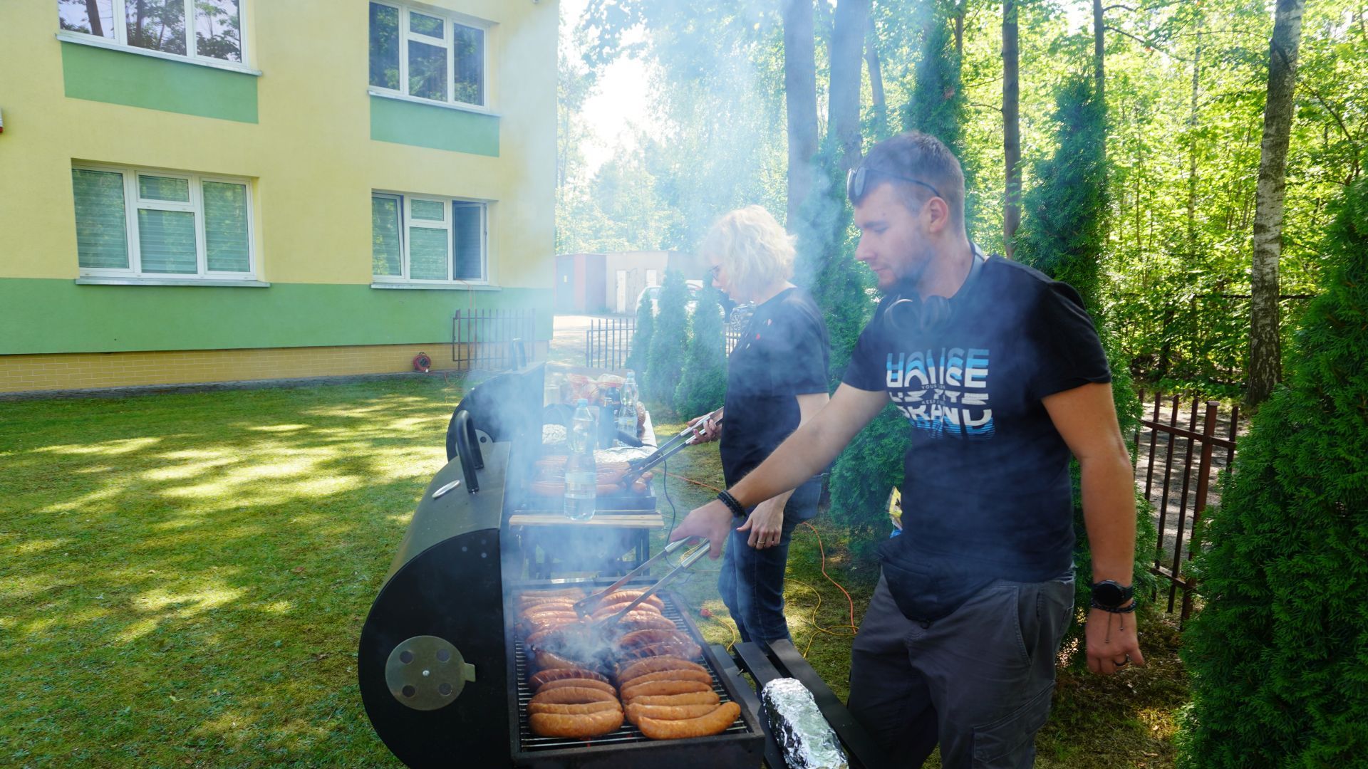 Pieczenie kiełbasek podczas grilla podsumowującego projekt ''Jesteśmy dla innych''.
