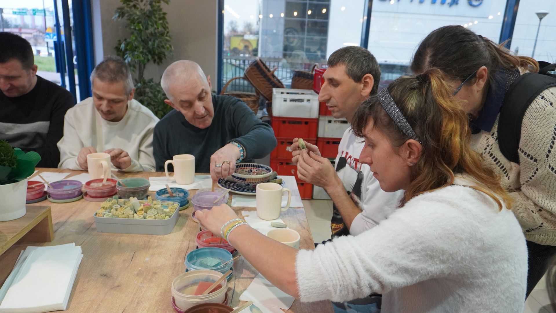 Uczestnicy naszego Domu ozdabiają gliniane kubki podczas Warsztatów Ceramiki Bolesławiec w Lublinie.