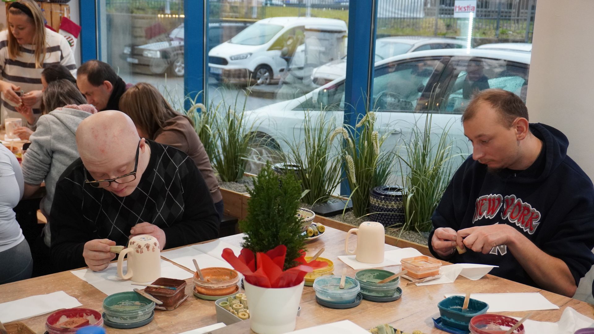 Uczestnicy naszego Domu ozdabiają gliniane kubki podczas Warsztatów Ceramiki Bolesławiec w Lublinie.