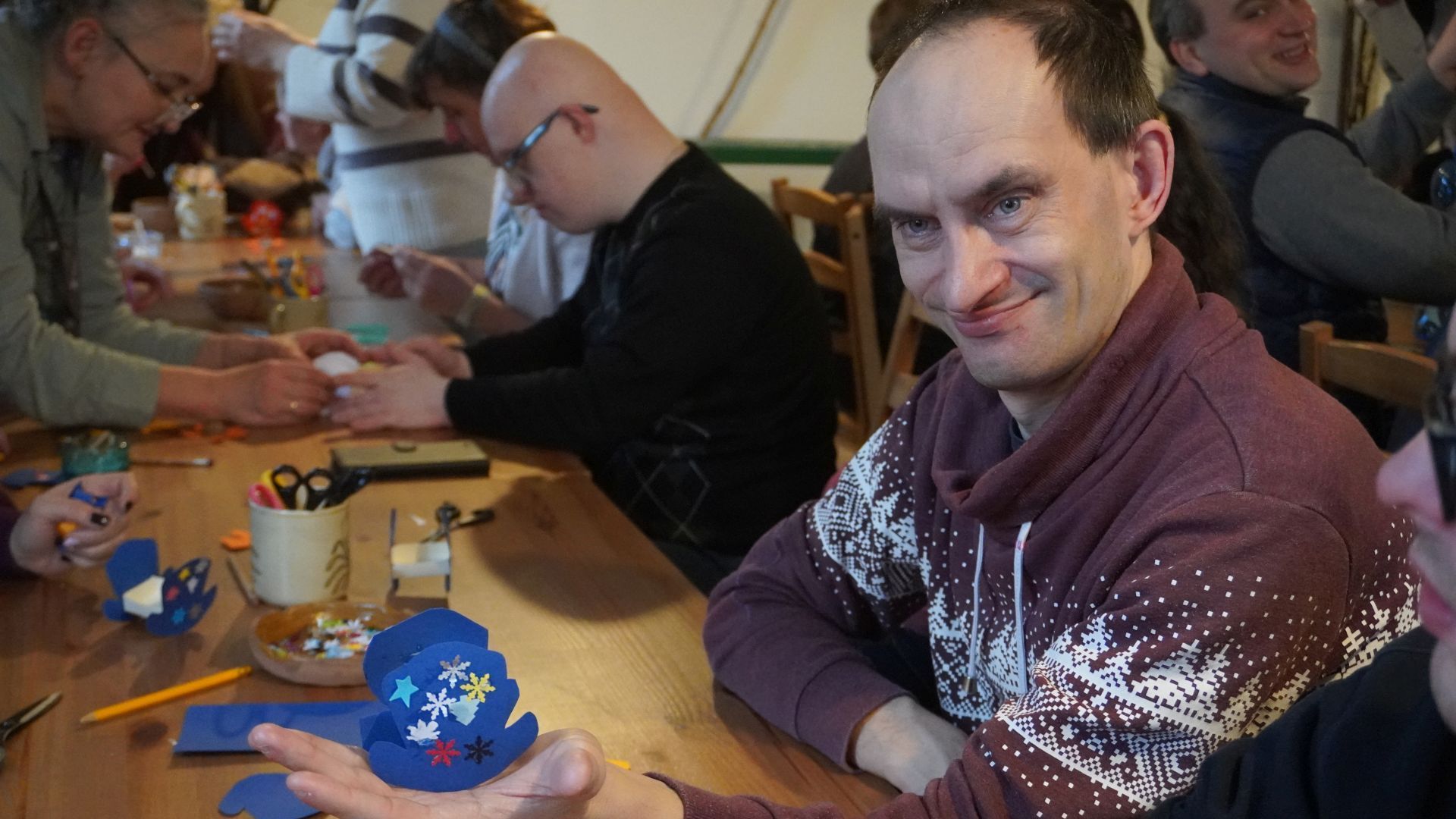 Uczestnik naszego Domu Paweł W. prezentuje ozdobę choinkową (kołyskę), którą zrobił podczas warsztatów wykonywania ozdób choinkowych w Muzeum Wsi Lubelskiej.