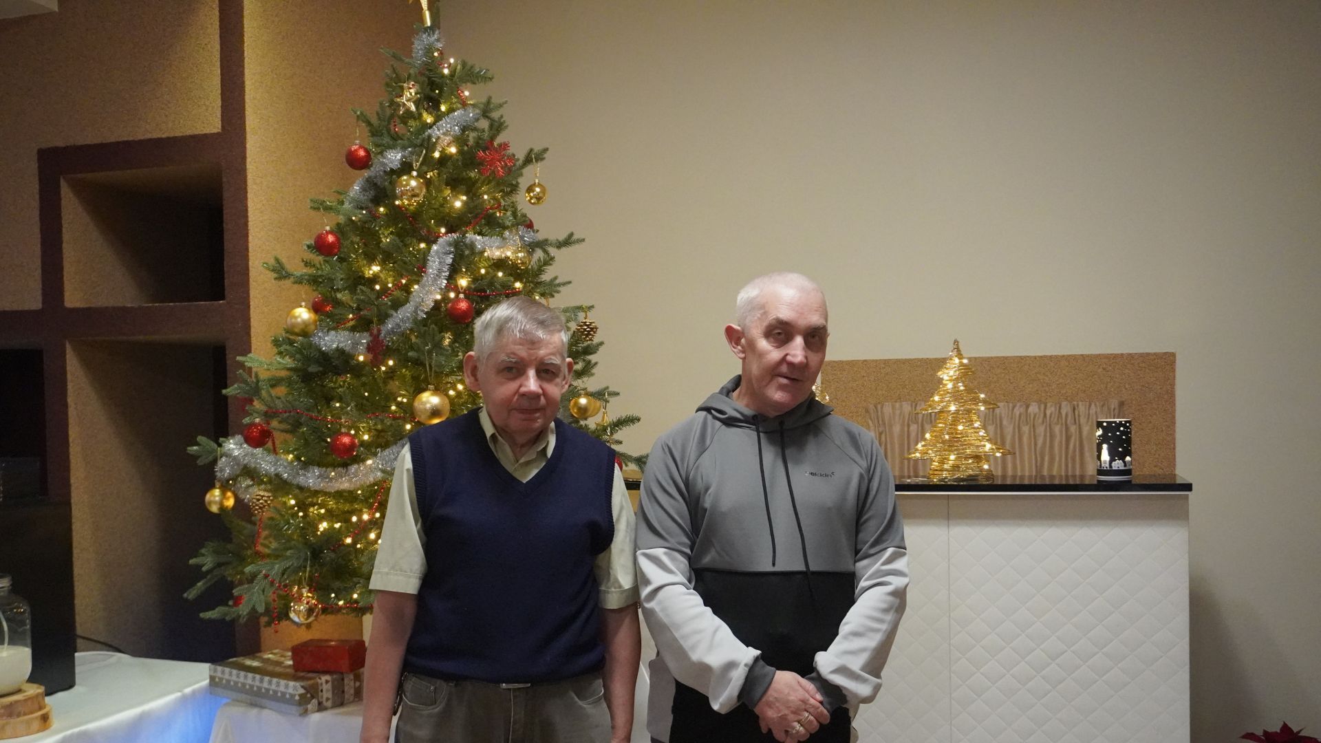 Uczestnicy PŚDS Sławomir i Tadeusz stoją przy choince podczas spotkania opłatkowego 2025.