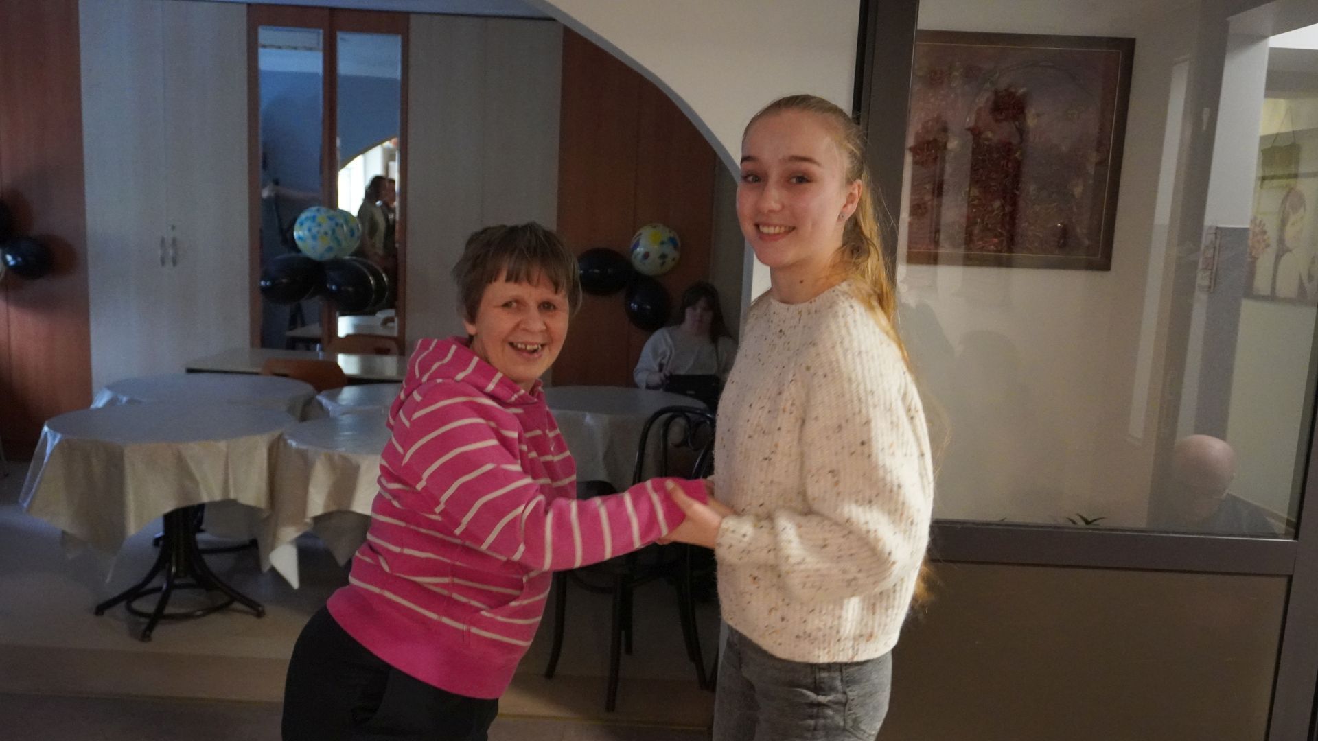 Uczestniczka naszego Domu Iwona tańczy z terapeutką podczas imprezy andrzejkowej 2025.