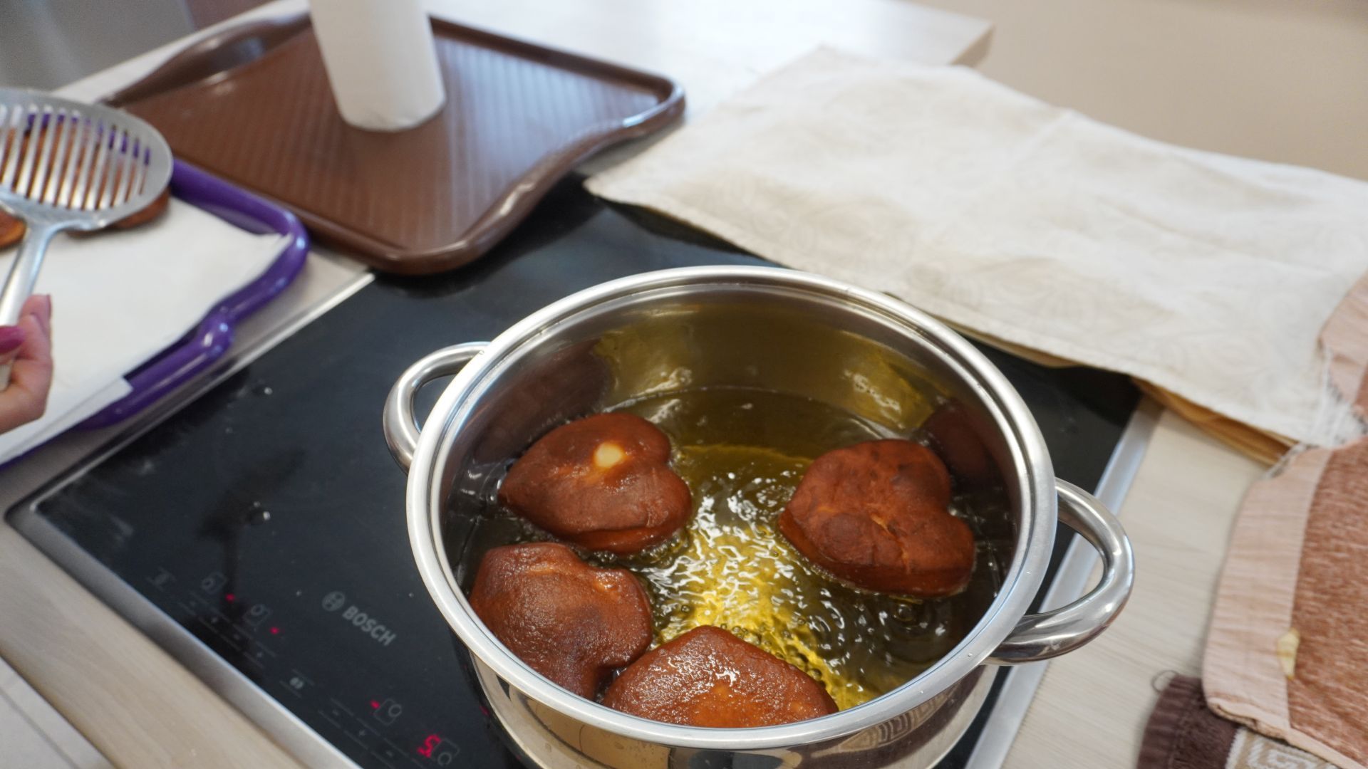 Smażące się w oleju pączki na Tłusty Czwartek.