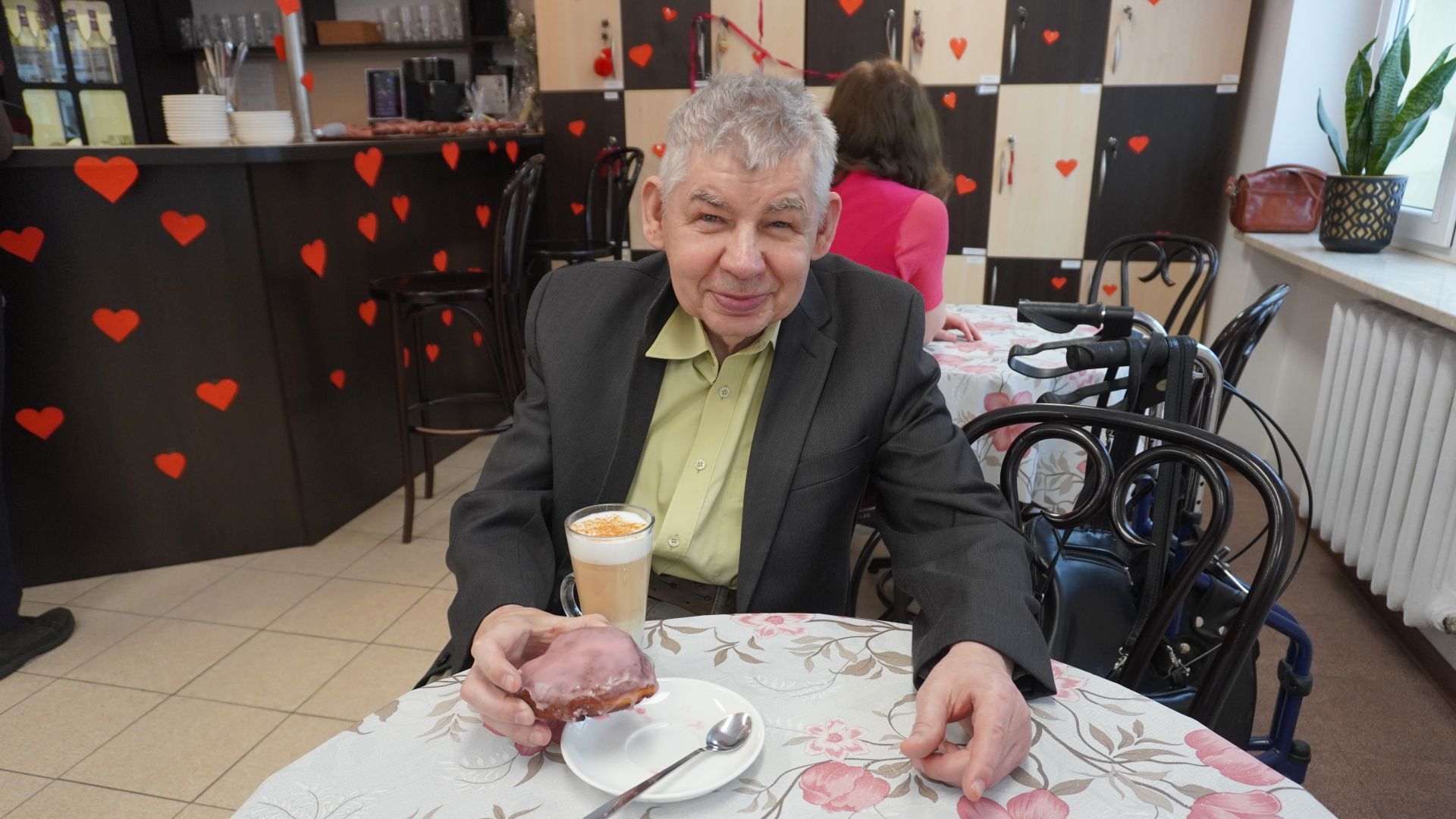 Uczestnik Sławomir w Art.-kawiarni je pączka z okazji Tłustego Czwartku.