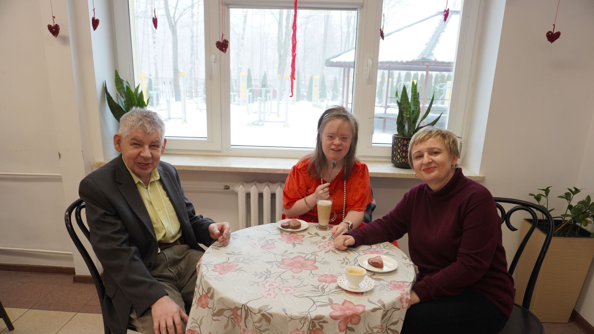 Uczestnicy wraz z panią dyrektor Justyną Juszczak świętują Tłusty Czwartek - jedzą pączki i piją kawę.