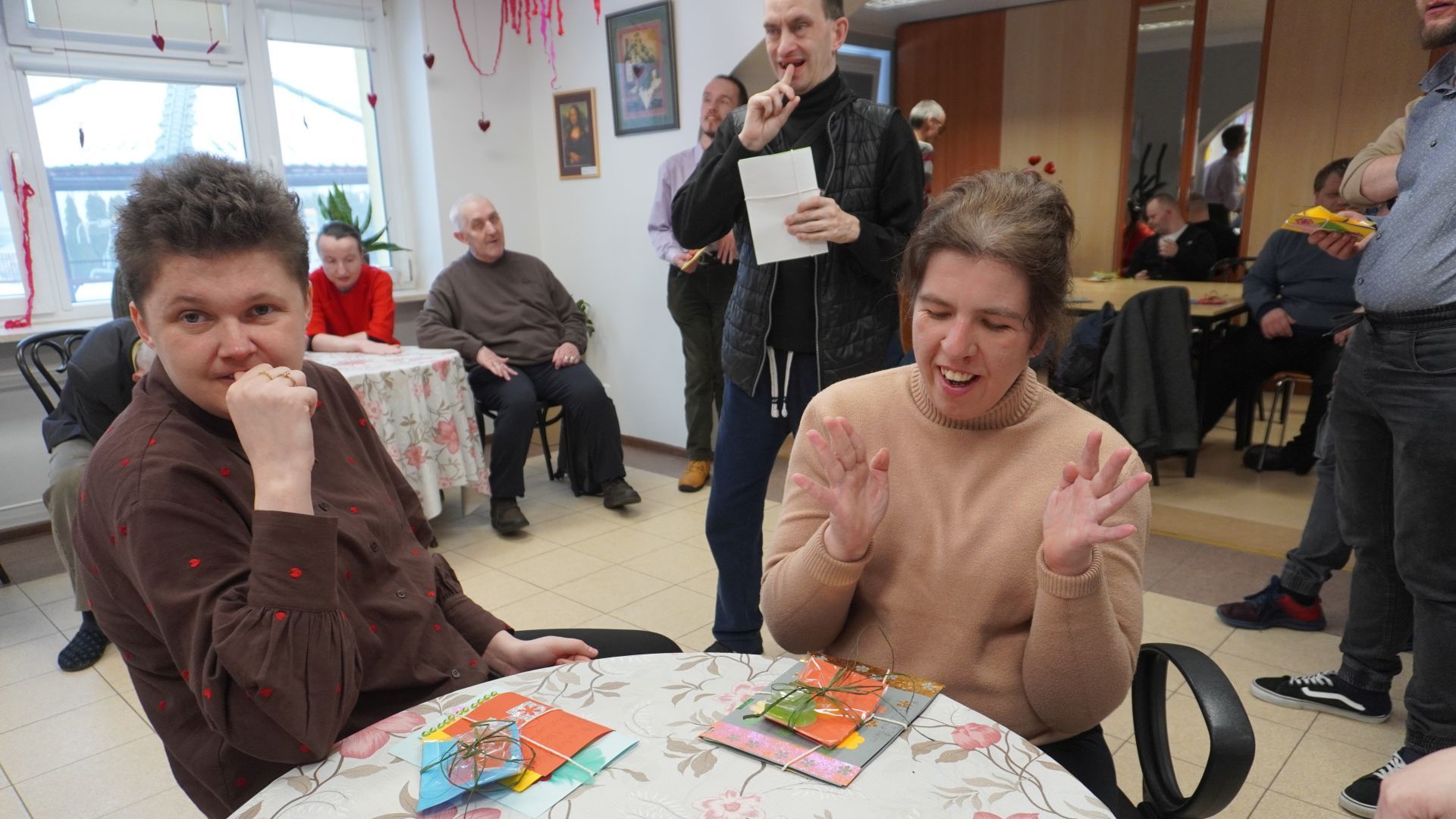 Uczestniczki Aneta i Ewelina siedzą przy stoliku z kartkami walentynkowymi, które dostały.