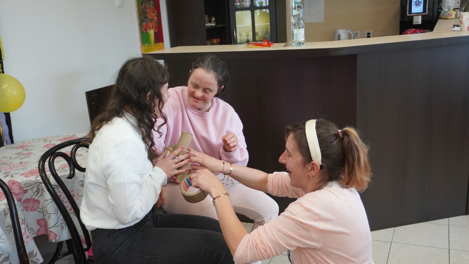 Uczestniczki sklejają wieżę z rolek po papierze toaletowym podczas zajęć integracyjnych z okazji Dnia Kobiet i Mężczyzn.