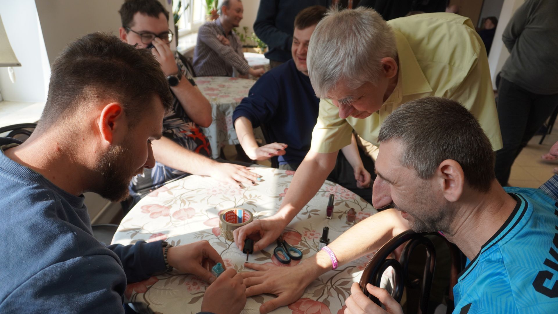 Panowie z PŚDS malują sobie paznokcie podczas zajęć integracyjnych z okazji Dnia Kobiet i Mężczyzn. 