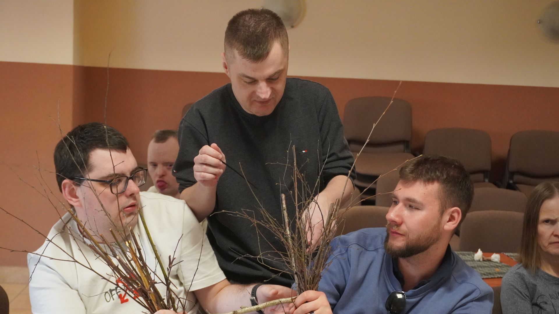 Uczestnicy: Karol, Łukasz i Bartek wspólnie formują koszyk z gałązek, podczas wielkanocnych warsztatów artystycznych.