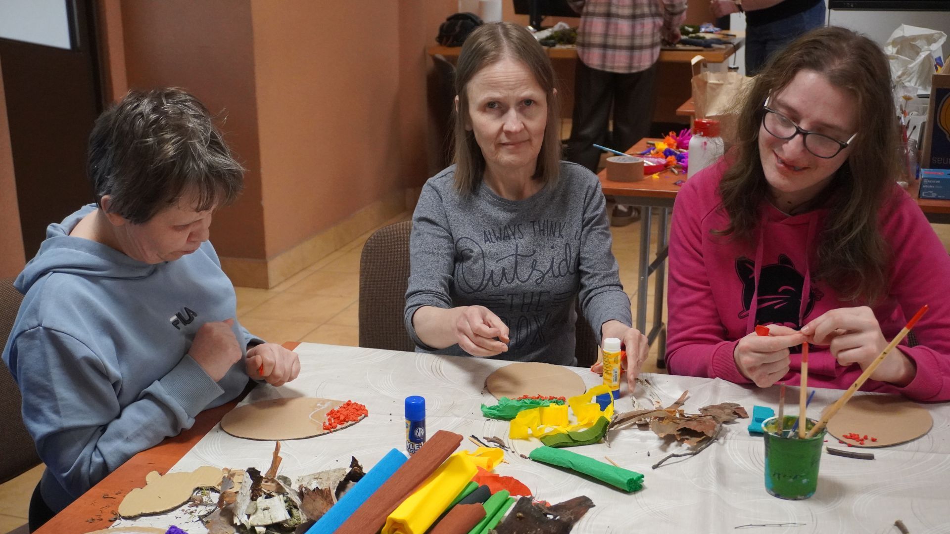 Uczestniczki: Iwona, Monika i Zuzia, podczas artystycznych warsztatów wielkanocnych ozdabiają tekturowe jajka kuleczkami z bibuły.