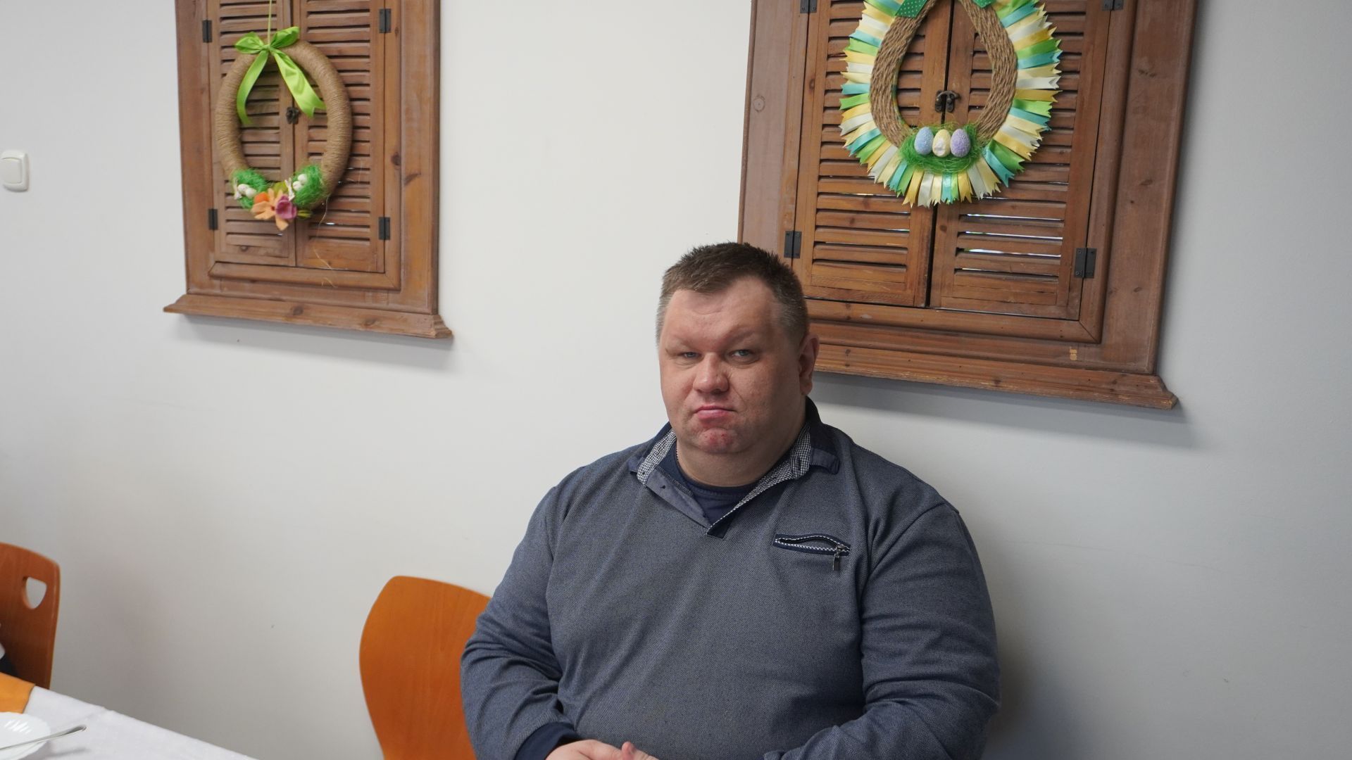 Uczestnik Marcin siedzi przy stole podczas spotkania wielkanocnego.