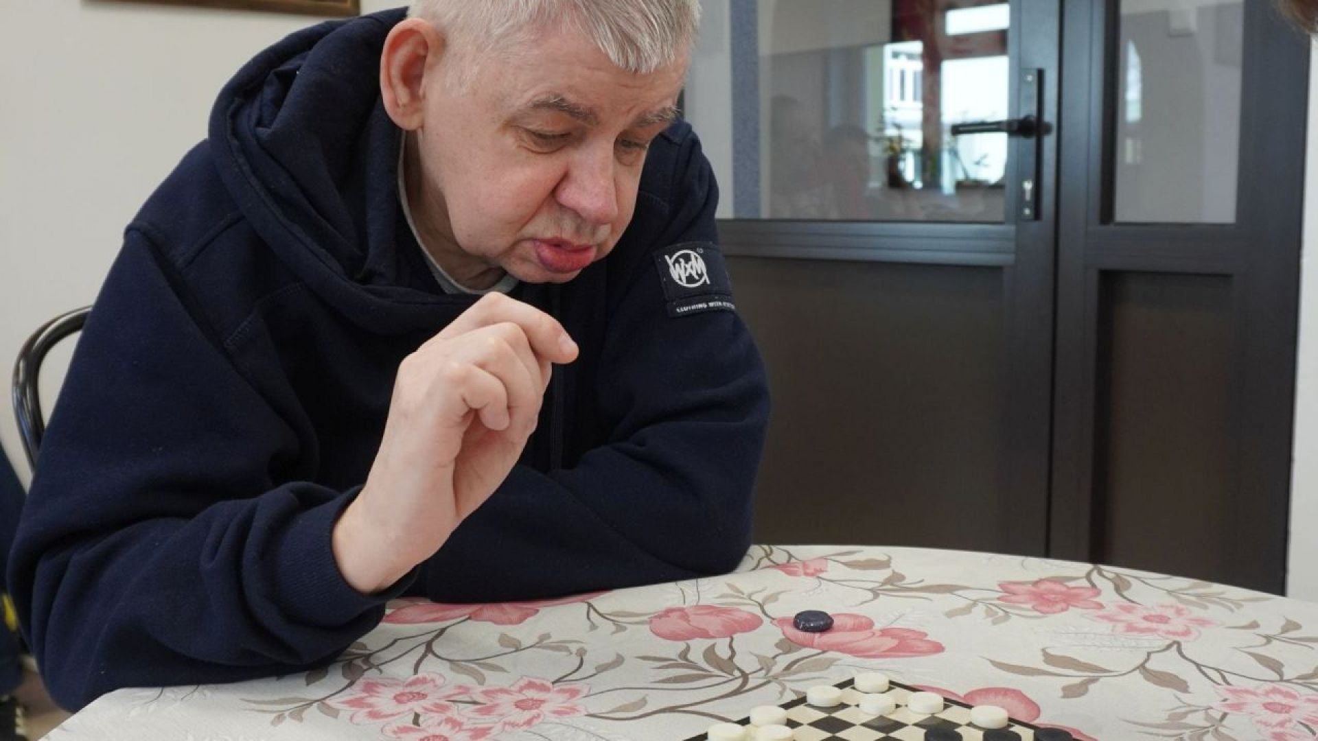 Uczestnik Sławomir gra w warcaby podczas Turnieju Warcabowego 2026. 