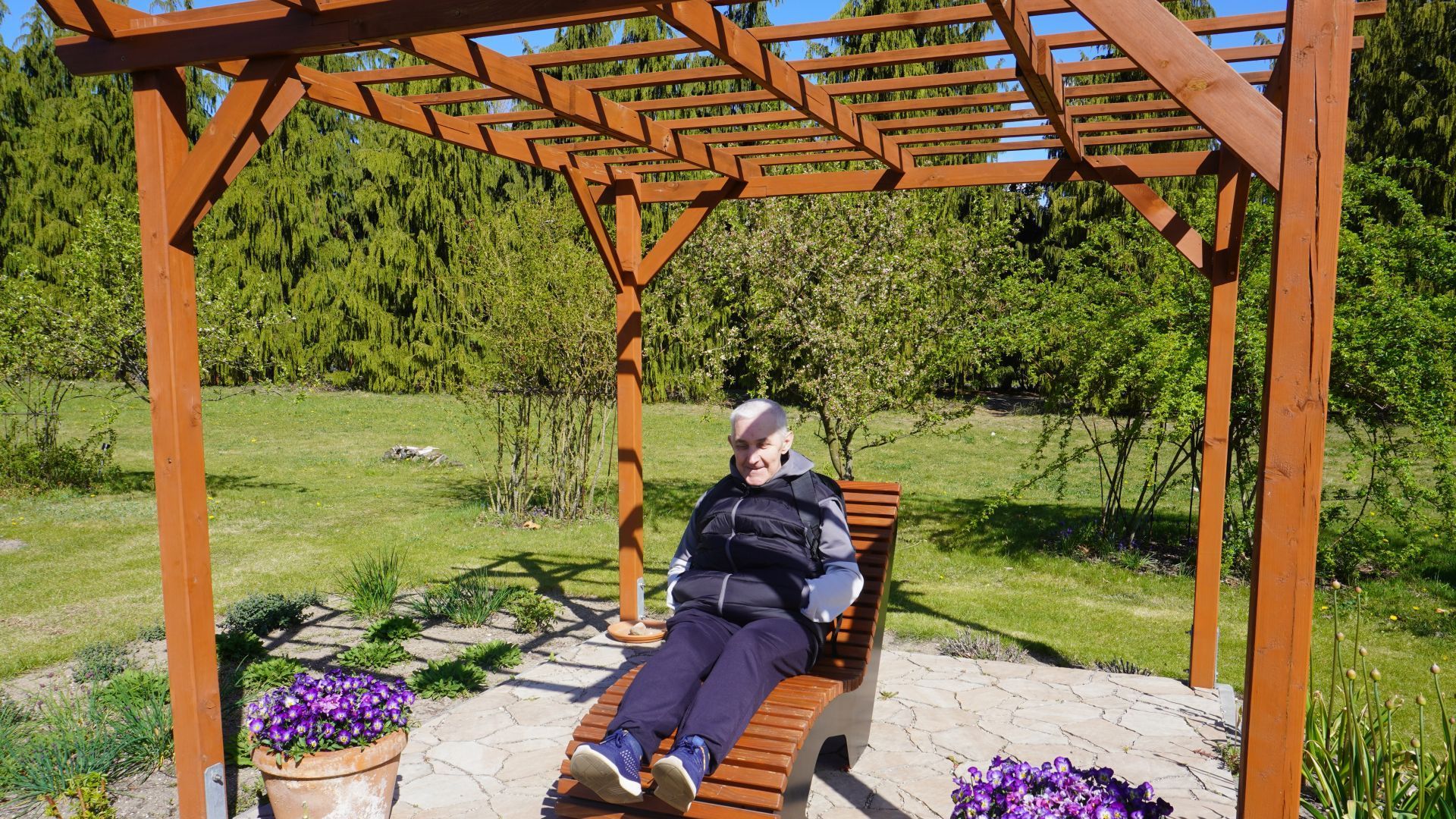 Uczestnik Tadeusz odpoczywa na leżaku w Ogrodzie Botanicznym w Powsinie.