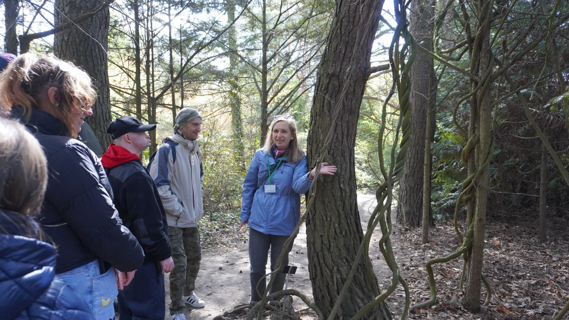 Pani przewodnik pokazuje uczestnikom liany w Ogrodzie Botanicznym w Powsinie. 
