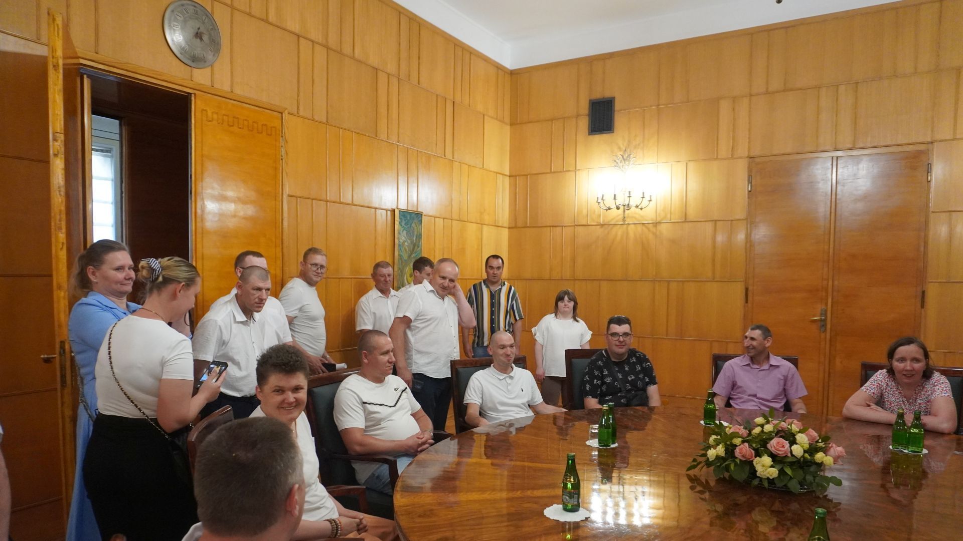 Uczestnicy naszego Domu wraz z innymi zwiedzającymi siedzą przy stole w Kancelarii Prezesa Rady Ministrów.