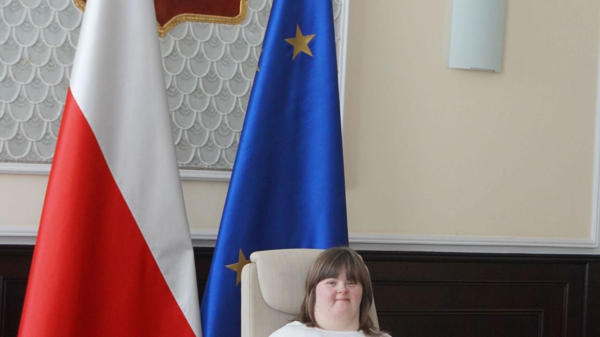 Uczestniczka naszego Domu Sylwia siedzi w fotelu premiera podczas zwiedzania Kancelarii Prezesa Rady Ministrów.