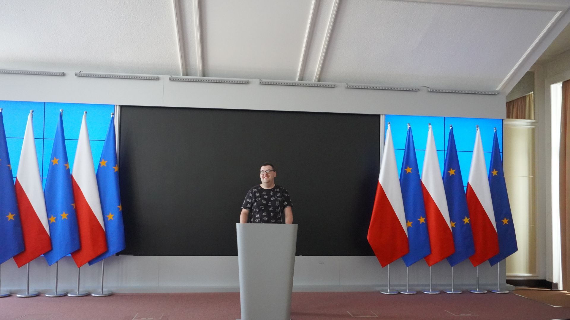 Uczestnik naszego Domu Karol stoi przy mównicy podczas zwiedzania Kancelarii Prezesa Rady Ministrów.