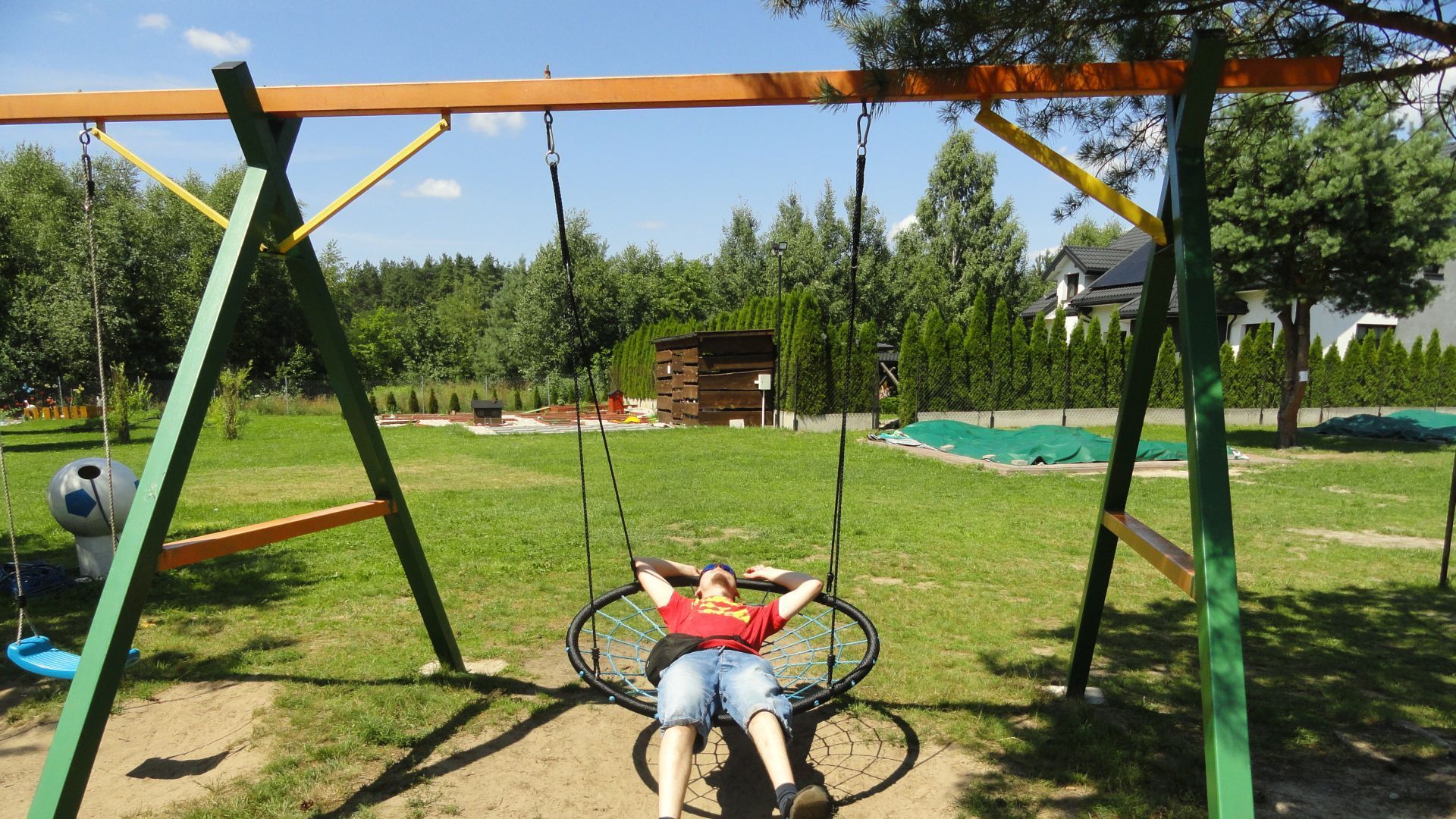 Uczestnik naszego Domu Maciej odpoczywa na huśtawce w Siedlisku Blisko Natury.