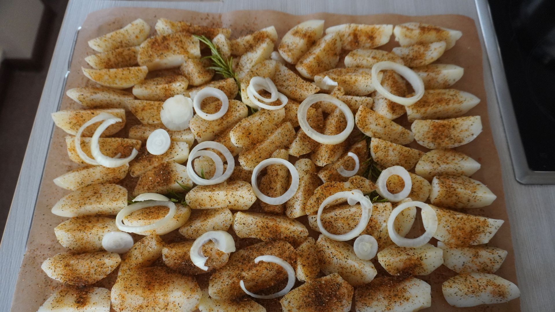 Aktualności: Pokrojone ziemniaki posypane przyprawami przygotowane do pieczenia.