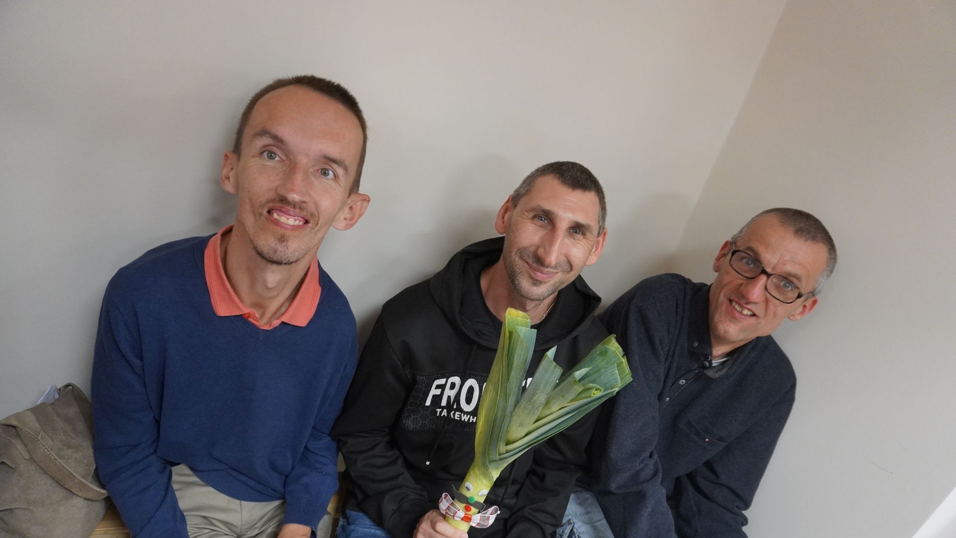 Uczestnicy Rafał, Sebastian i Grzegorz pozują do zdjęcia z porem podczas Święta Warzyw ''Dzień Pora'' w ŚDS w Siedlcach.