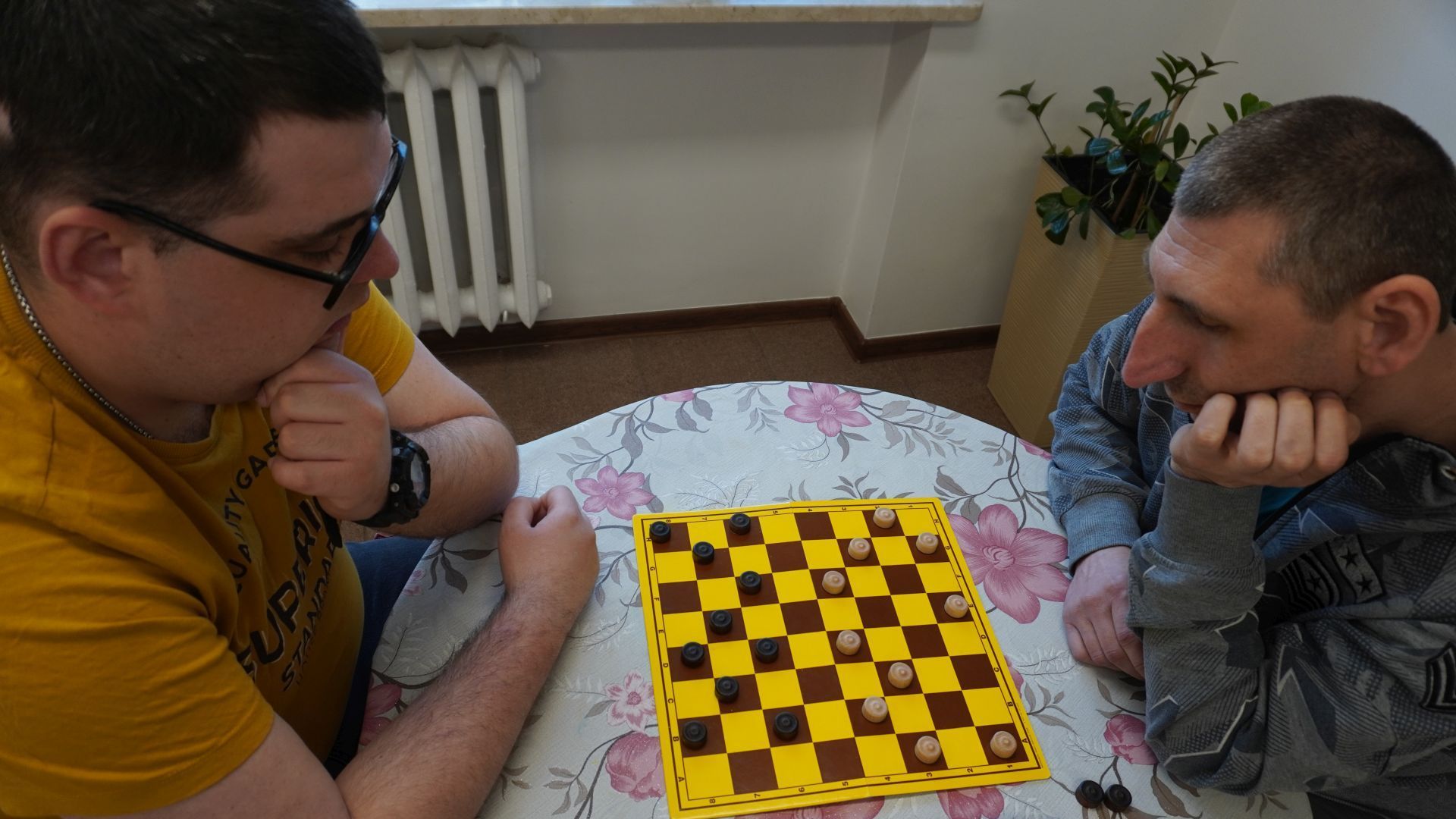 Uczestnicy Karol i Sebastian grają w warcaby podczas Turnieju Warcabowego 2026.